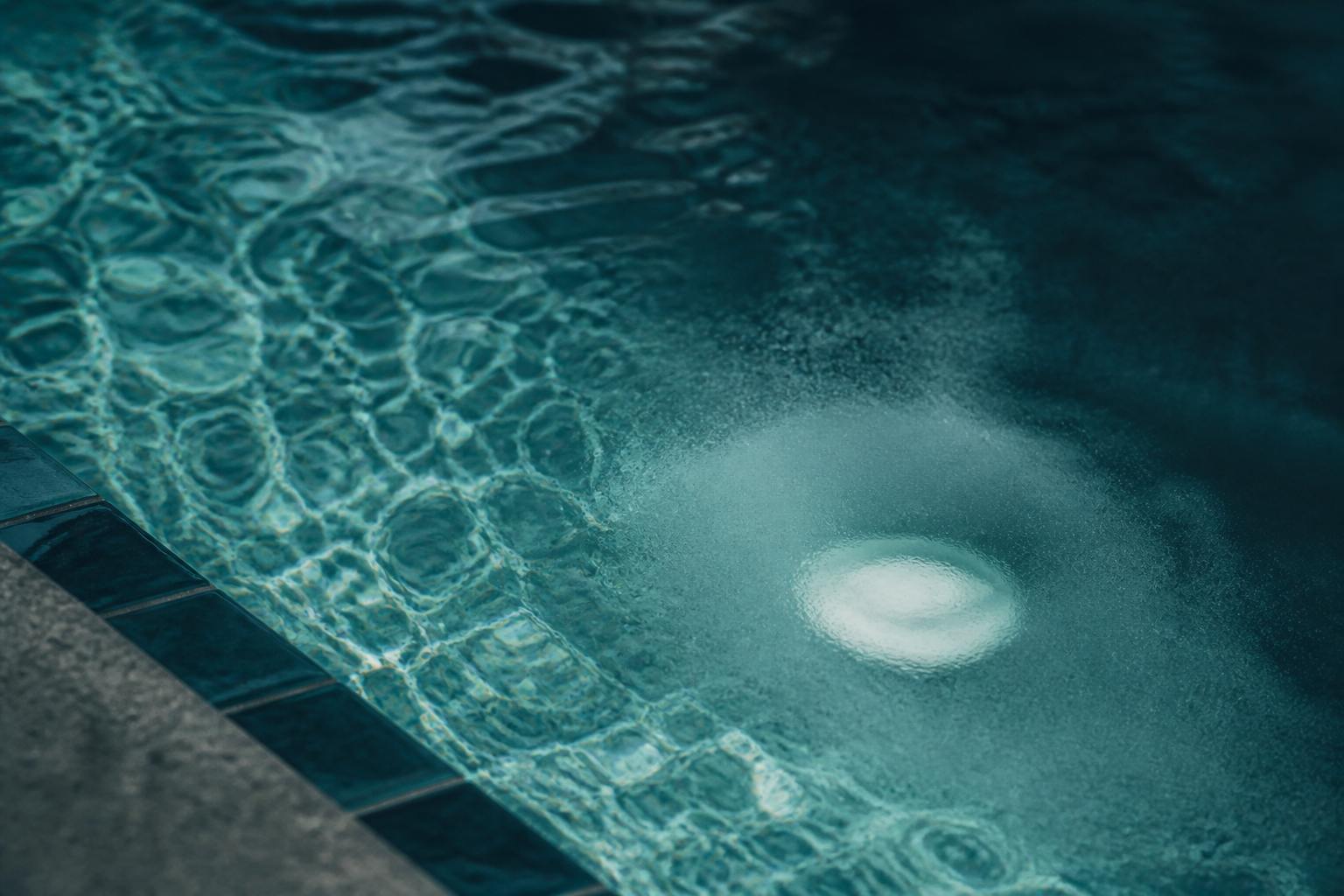 Close crop of swimming-pool water and a dissolving tablet